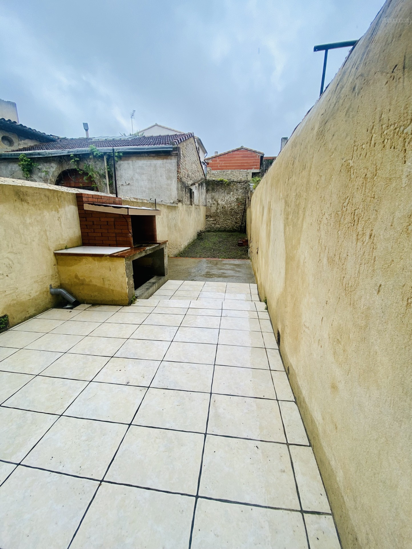 Immeuble à vendre à Castelnaudary : terrasse carrelée avec un barbecue en briques