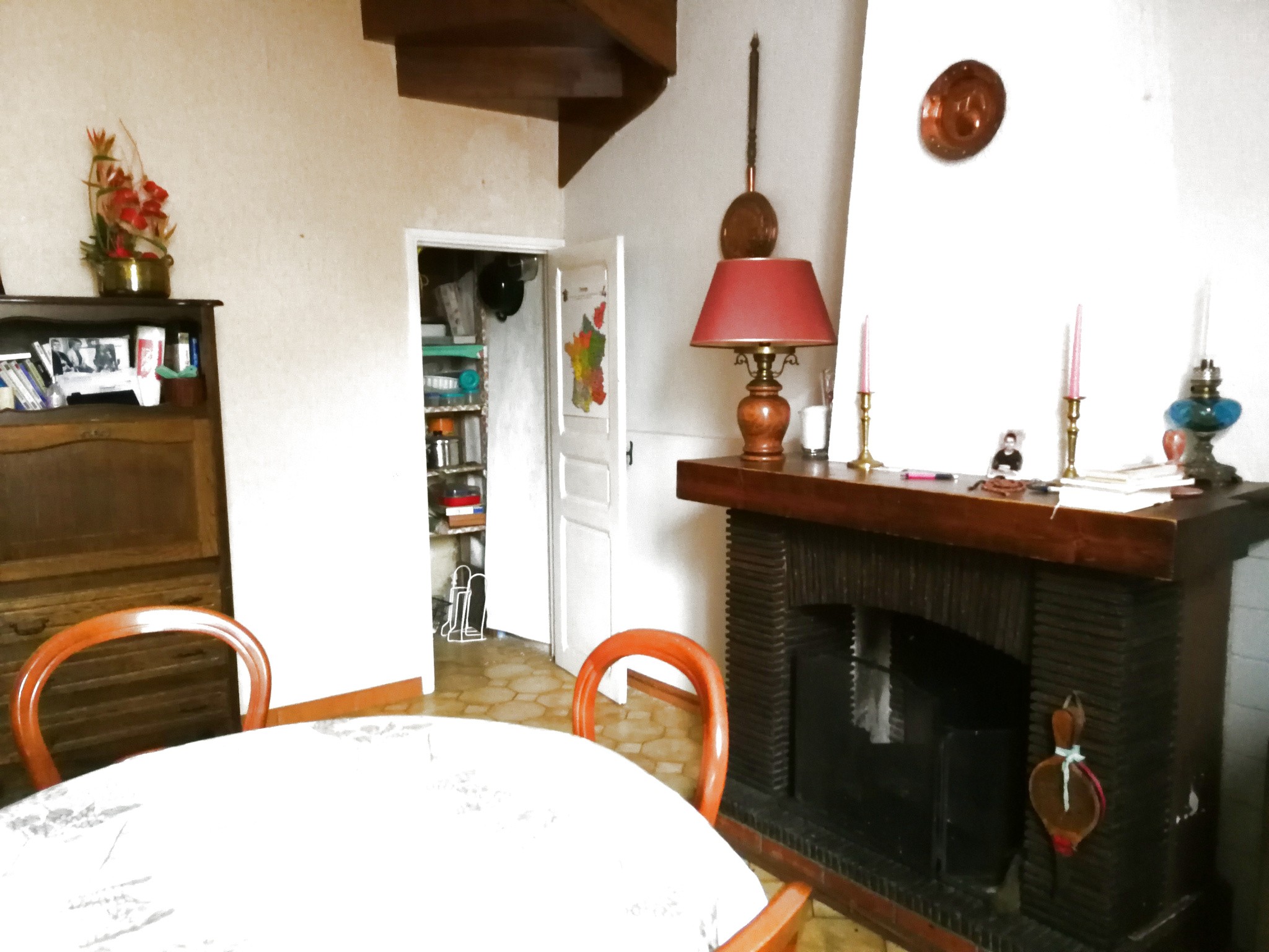 Maison à vendre à Blomac : table avec nappe blanche près d'une cheminée sombre