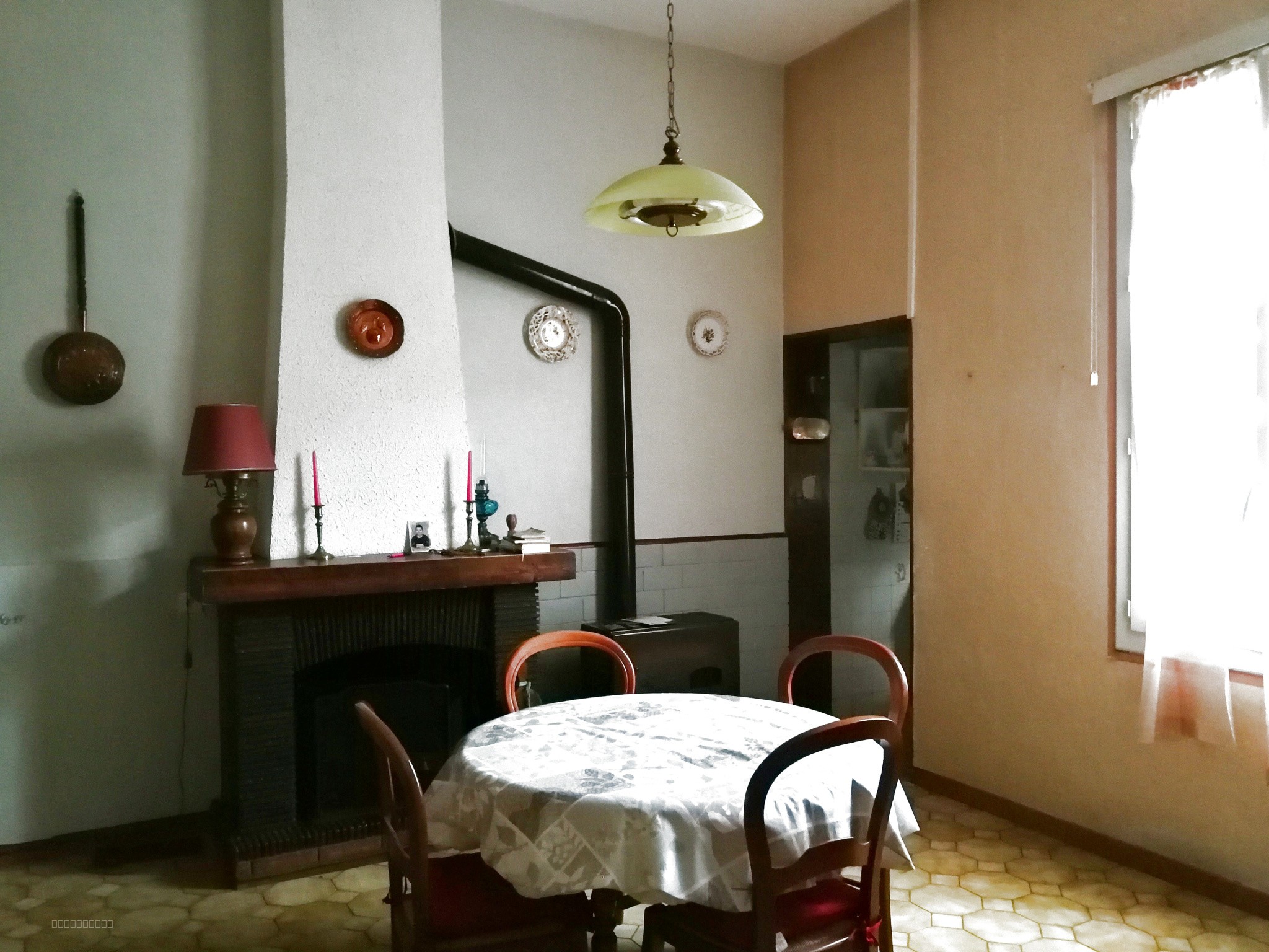 Maison à vendre à Blomac : salle à manger avec table ronde et cheminée ancienne