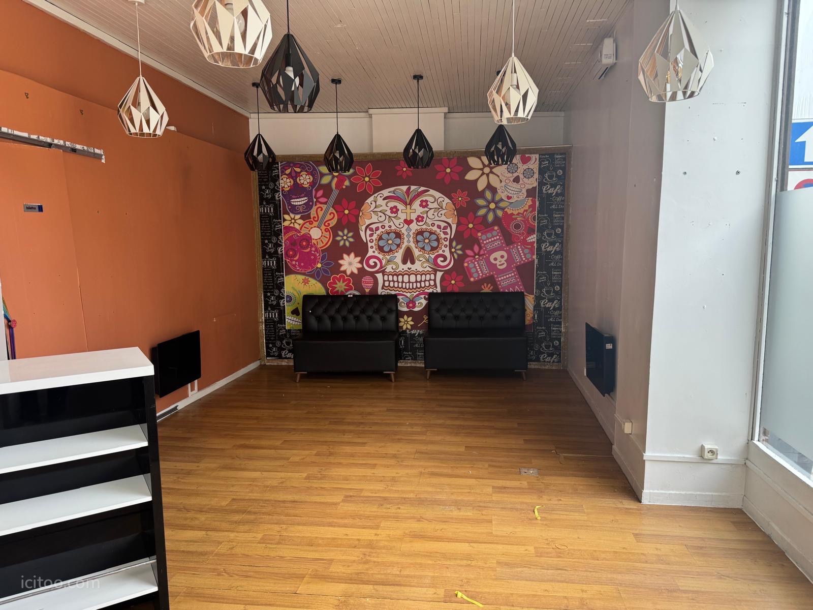 Local commercial à vendre à Douai : intérieur d'un local commercial avec mur décoré, luminaires et sol en bois