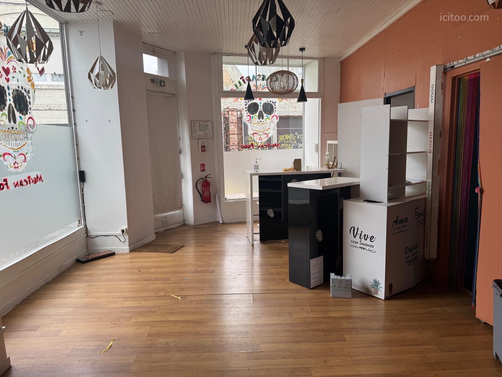 Local commercial à vendre à Douai : vue intérieure d'un local avec comptoirs, vitrines et porte vitrée