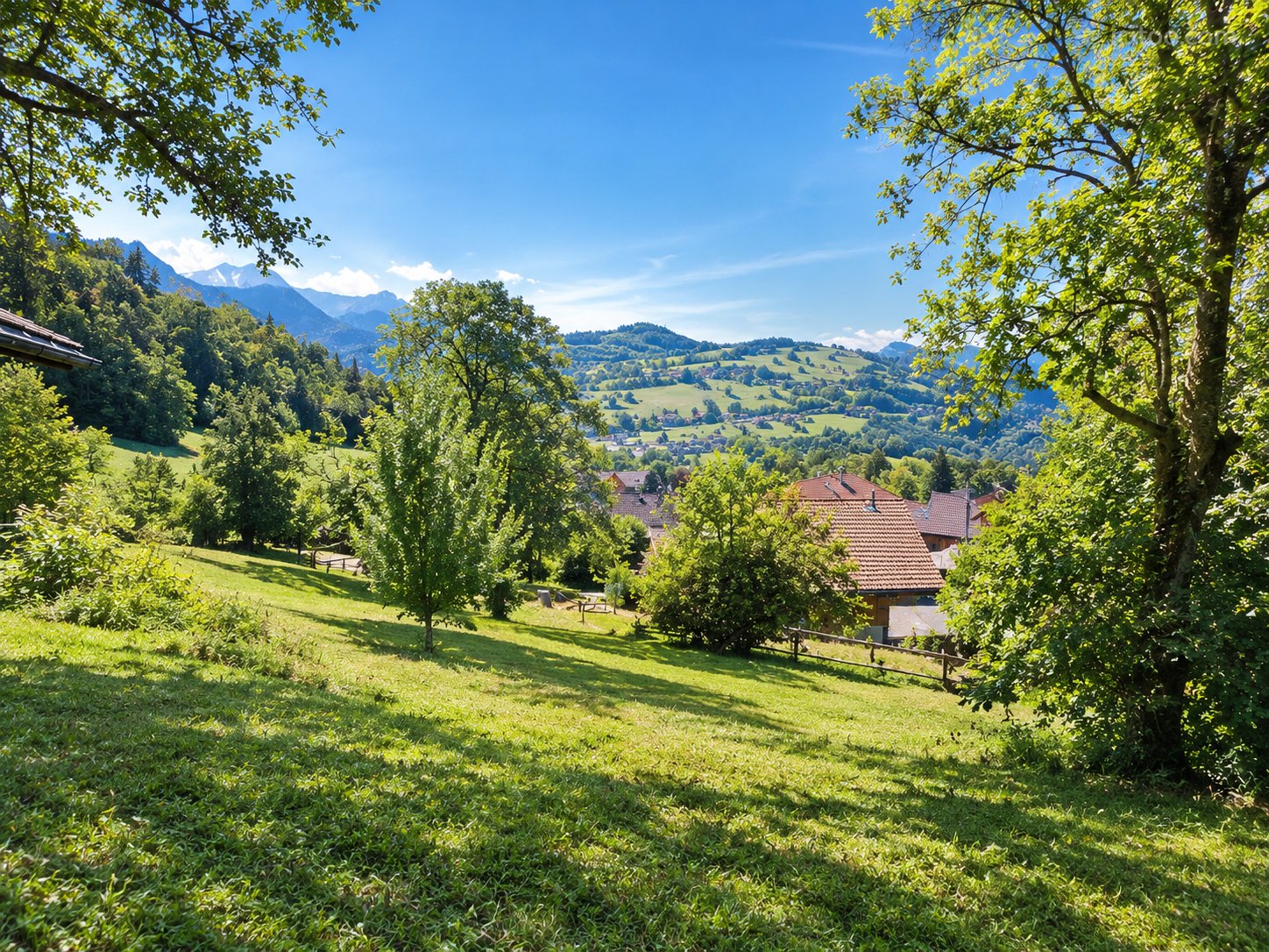 Terrain à vendre à Bogève (74250) : vaste terrain verdoyant avec vue sur des collines et des montagnes