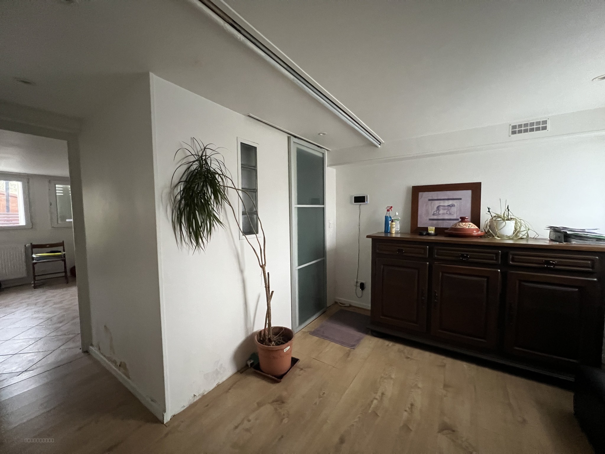 Maison à vendre à Louvres : couloir avec parquet clair et grand buffet en bois