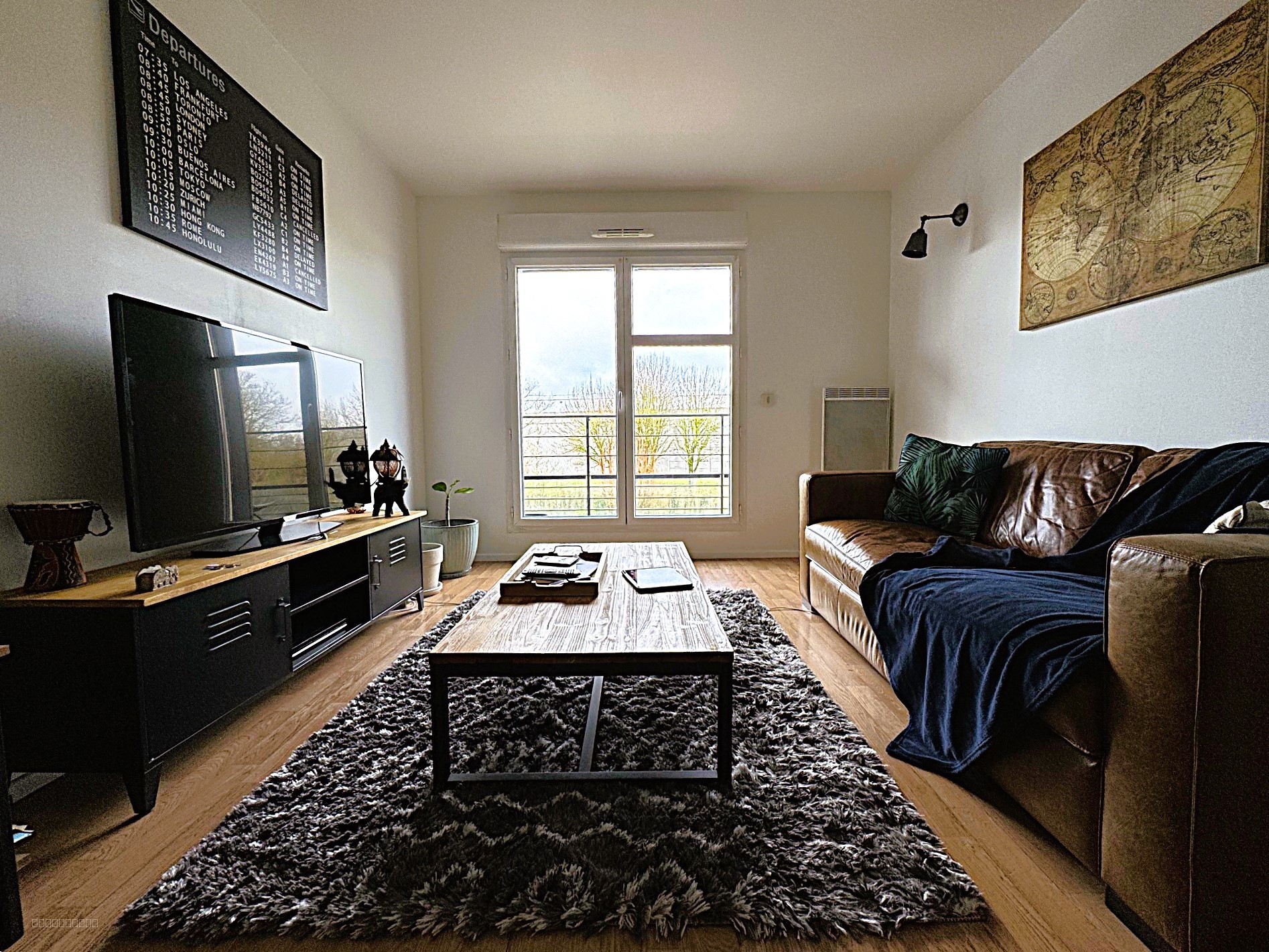 Appartement à vendre à Survilliers : salon avec canapé en cuir et grand écran plat