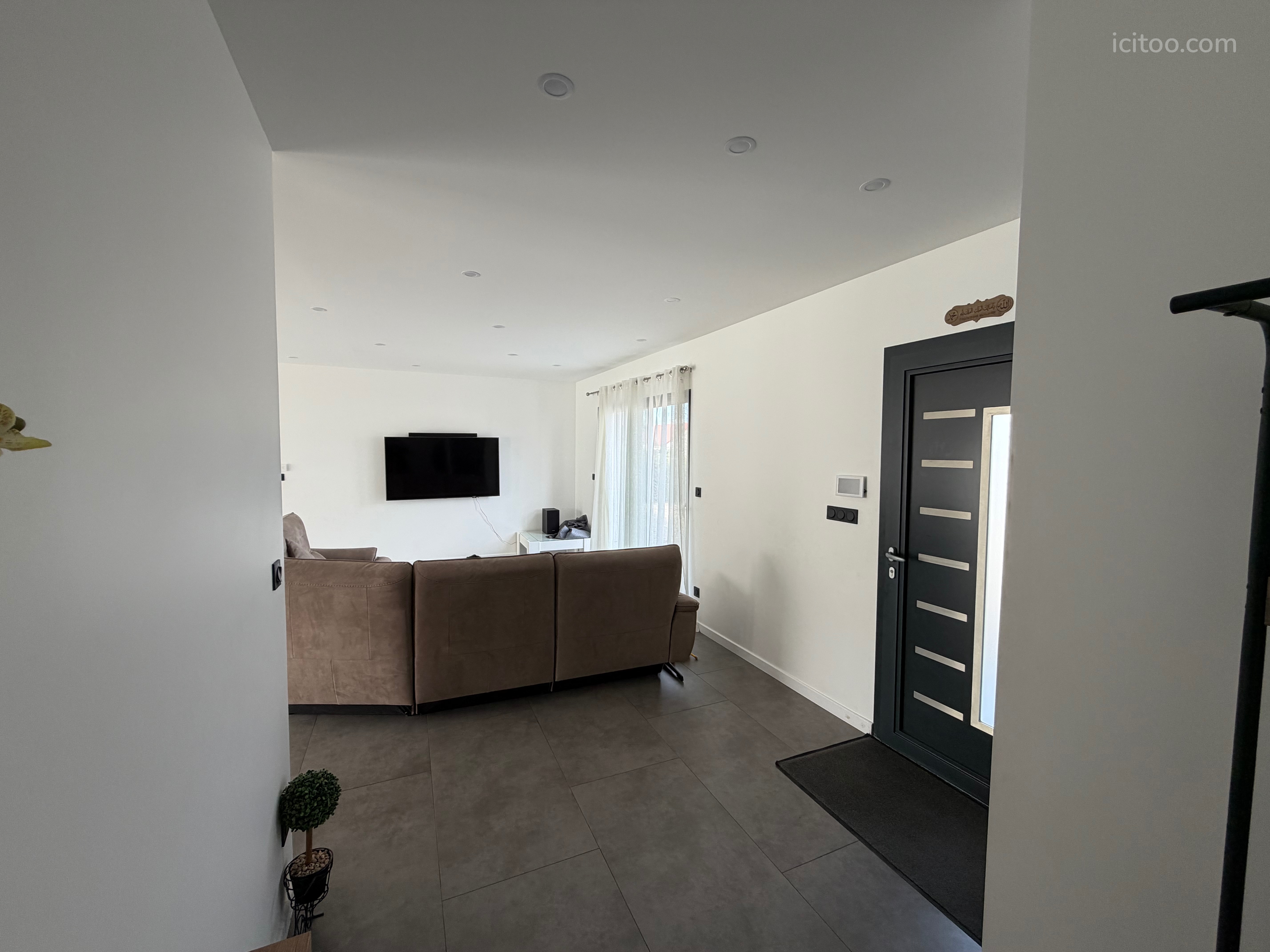 Maison à vendre à Le Controis-en-Sologne : salon avec canapé marron et télévision murale