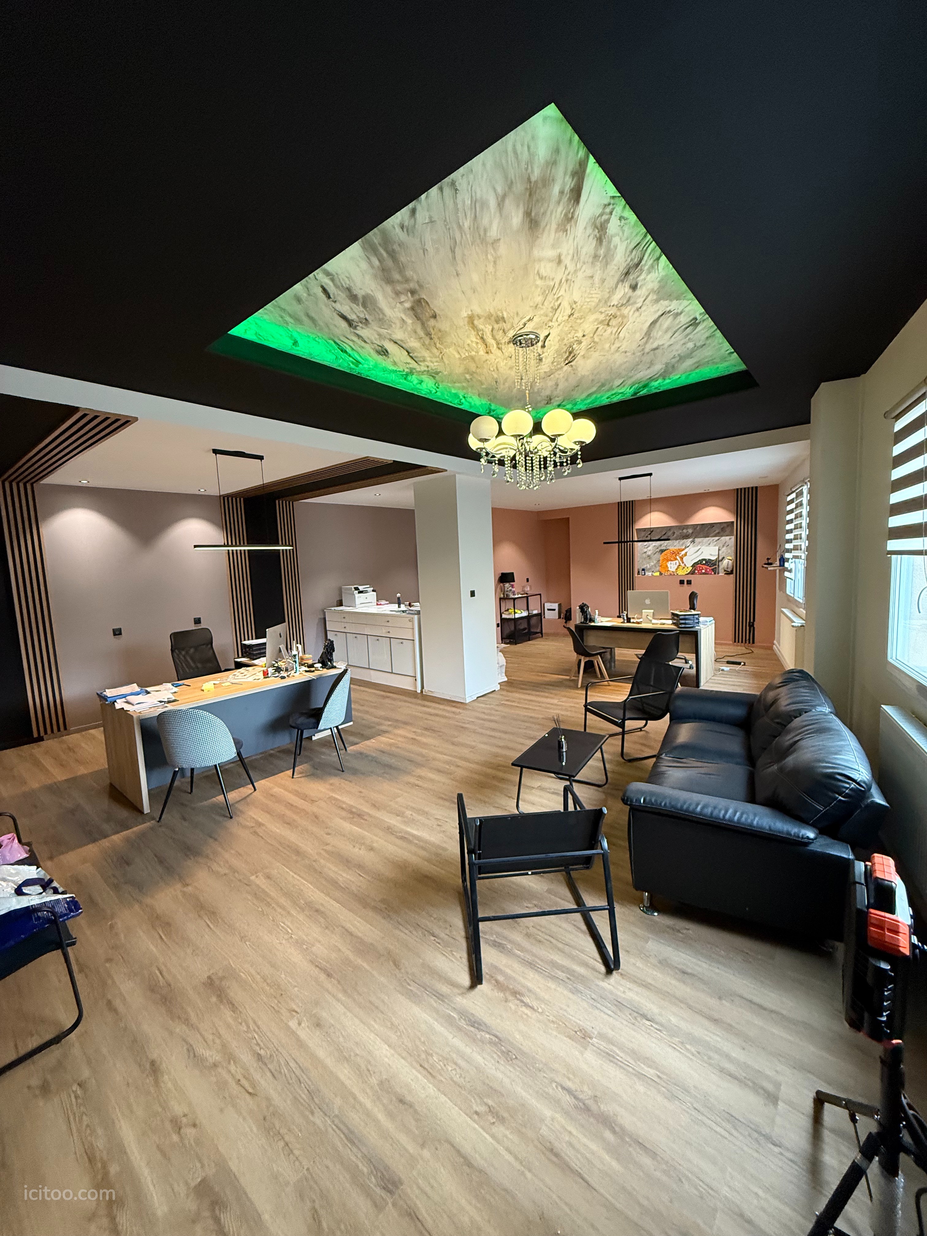 Entrepôt à louer à Saint-Étienne : bureau avec parquet, canapé noir et plafond décoratif