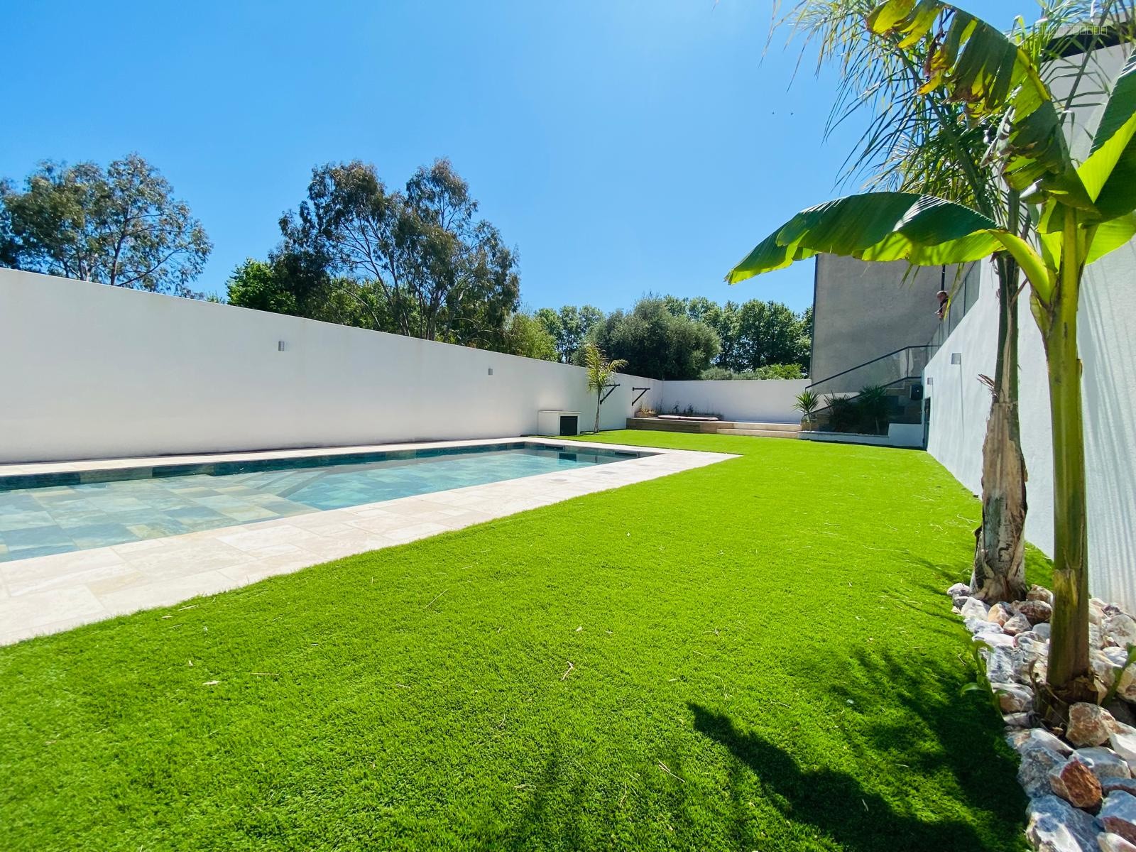 Villa à vendre à Bompas : pelouse verte entourant une piscine rectangulaire