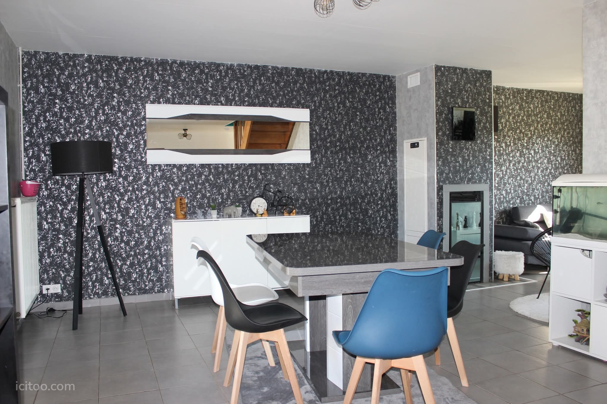 Maison à vendre à Lanthes : table de repas avec chaises bleues et mur à motifs