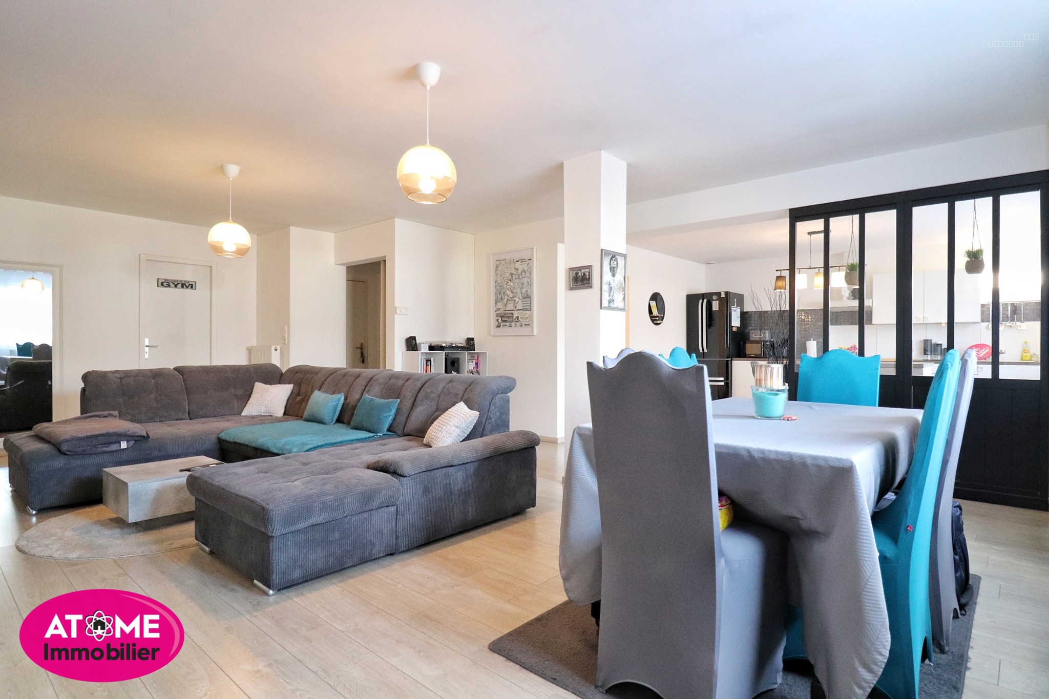 Immeuble à vendre à Homecourt : grand salon avec canapé gris et table dressée