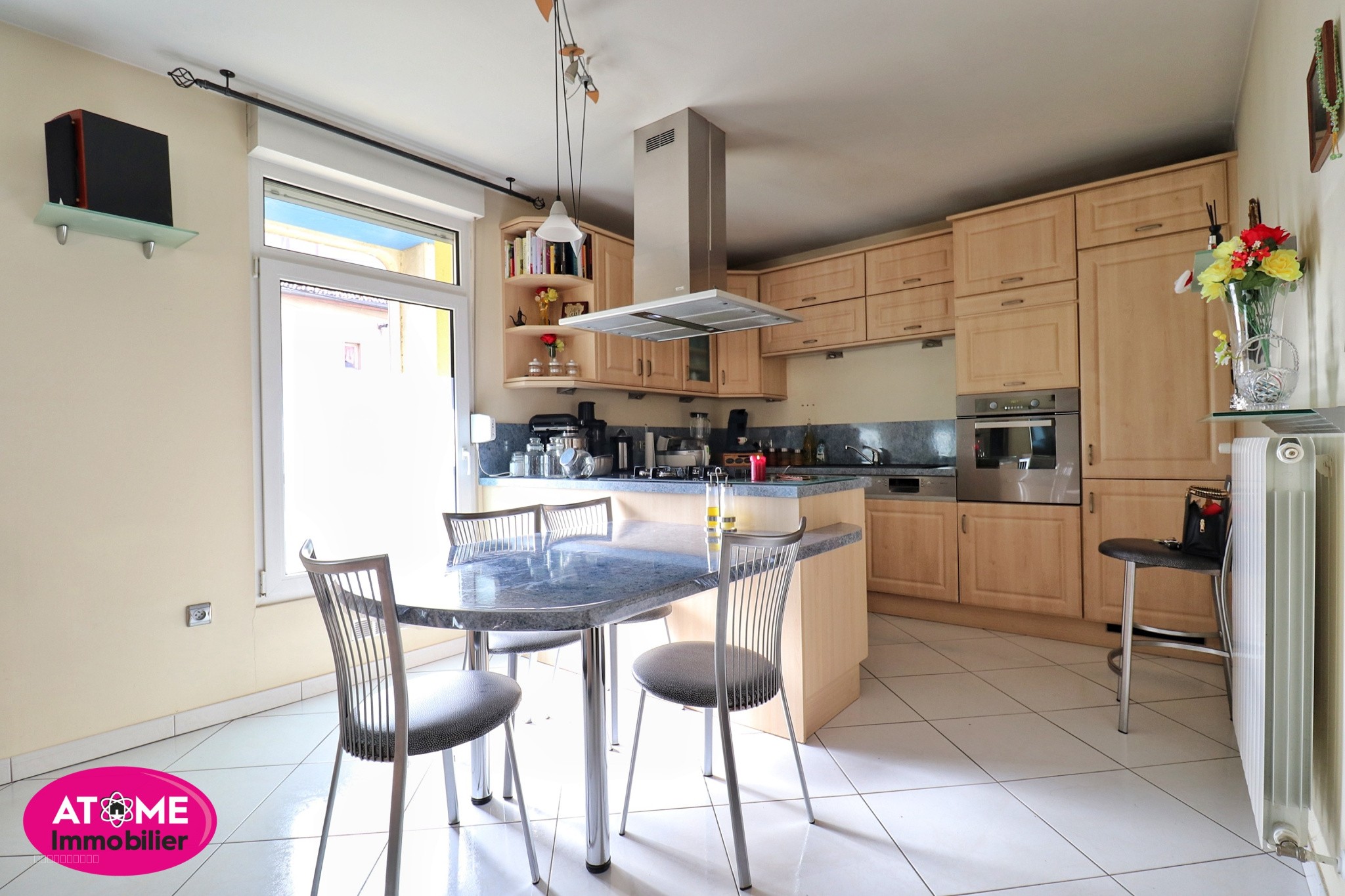 Maison à vendre à Homecourt : cuisine avec îlot central et chaises grises modernes