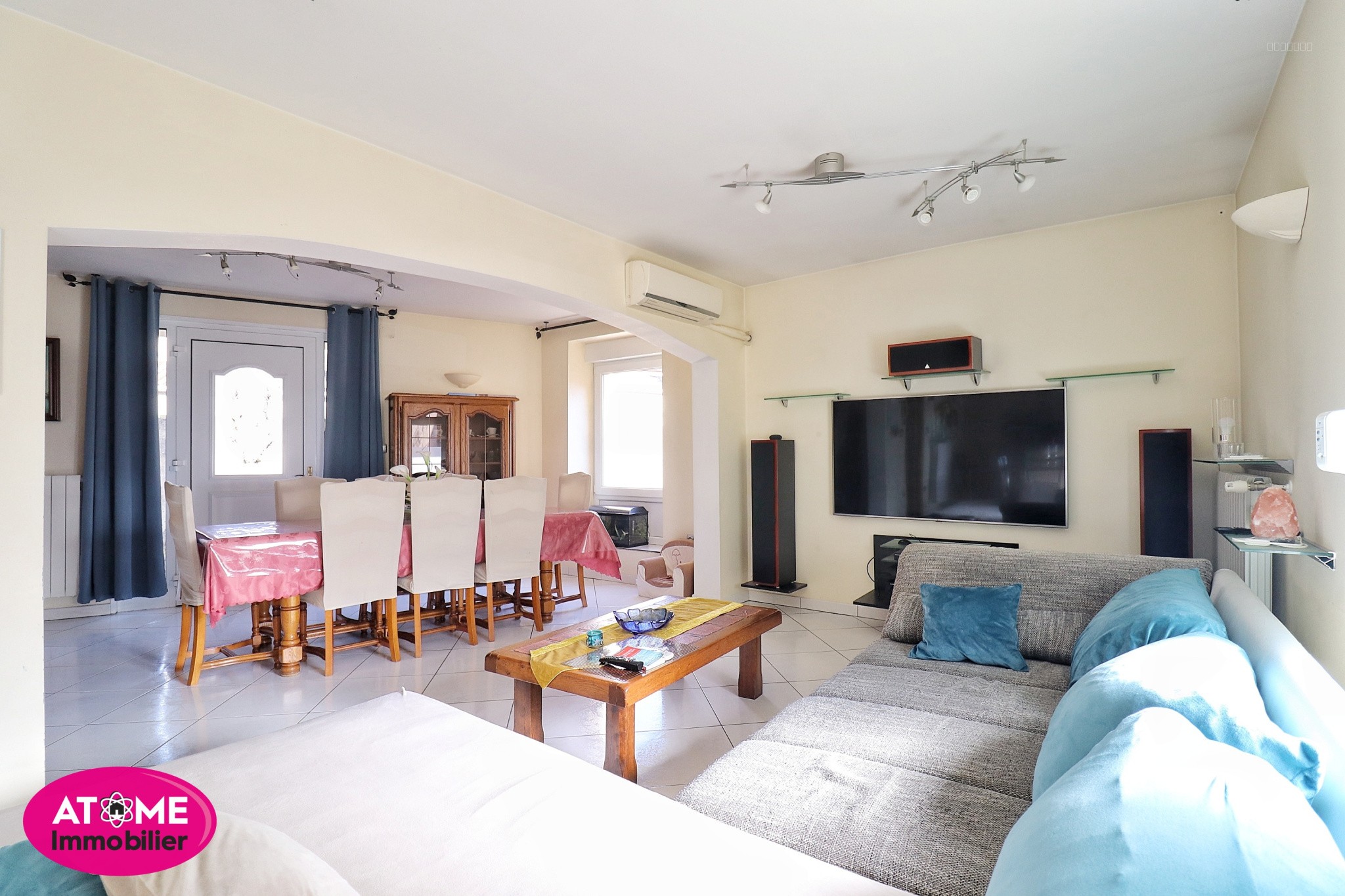 Maison à vendre à Homecourt : salon avec canapé gris et grand téléviseur mural