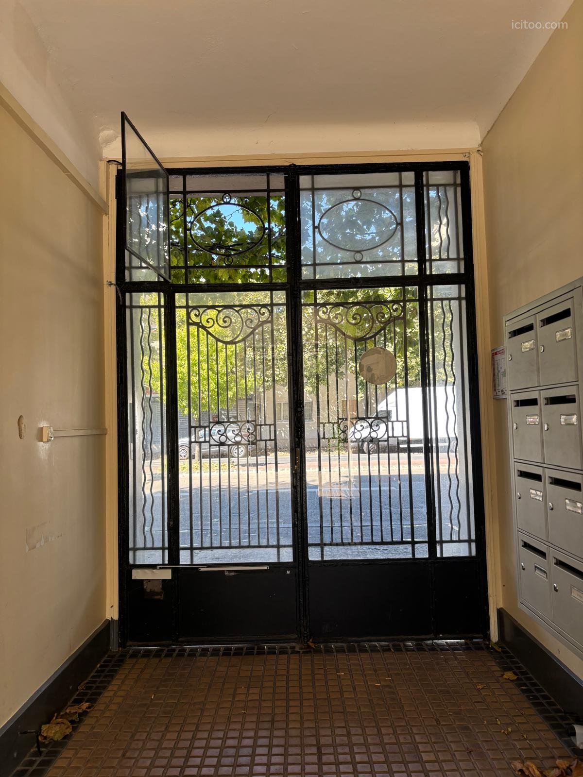 Appartement 2 pièces à vendre à Le Perreux-sur-Marne (94170) : porte d'entrée en fer forgé noir avec vue sur arbres