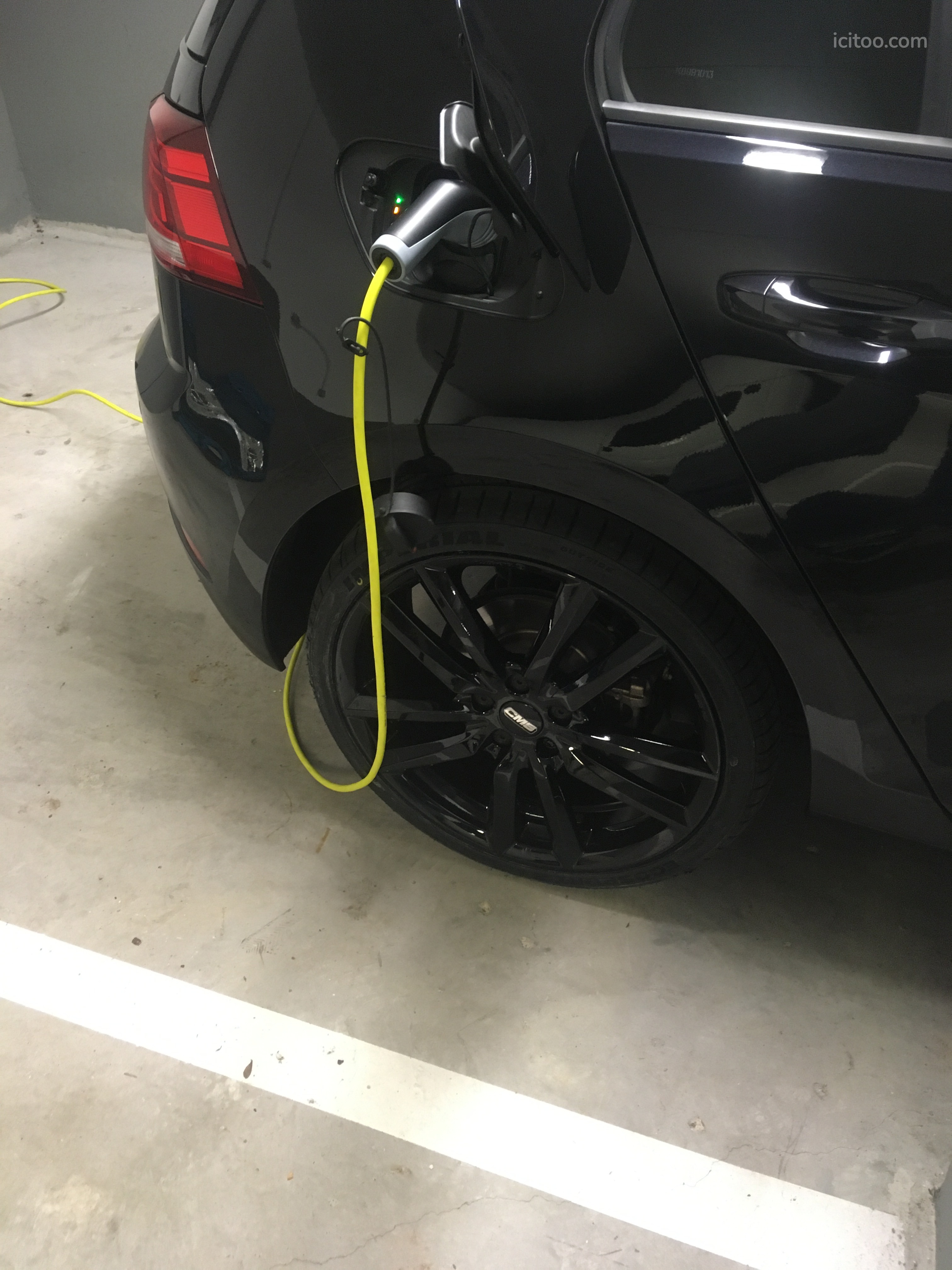 Garage à vendre à Bougival : câble de recharge jaune branché sur une voiture noire