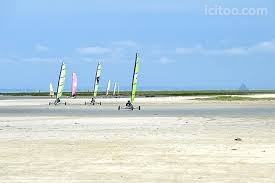 Terrain à vendre à Hirel : plusieurs planches à voile sur une étendue de sable