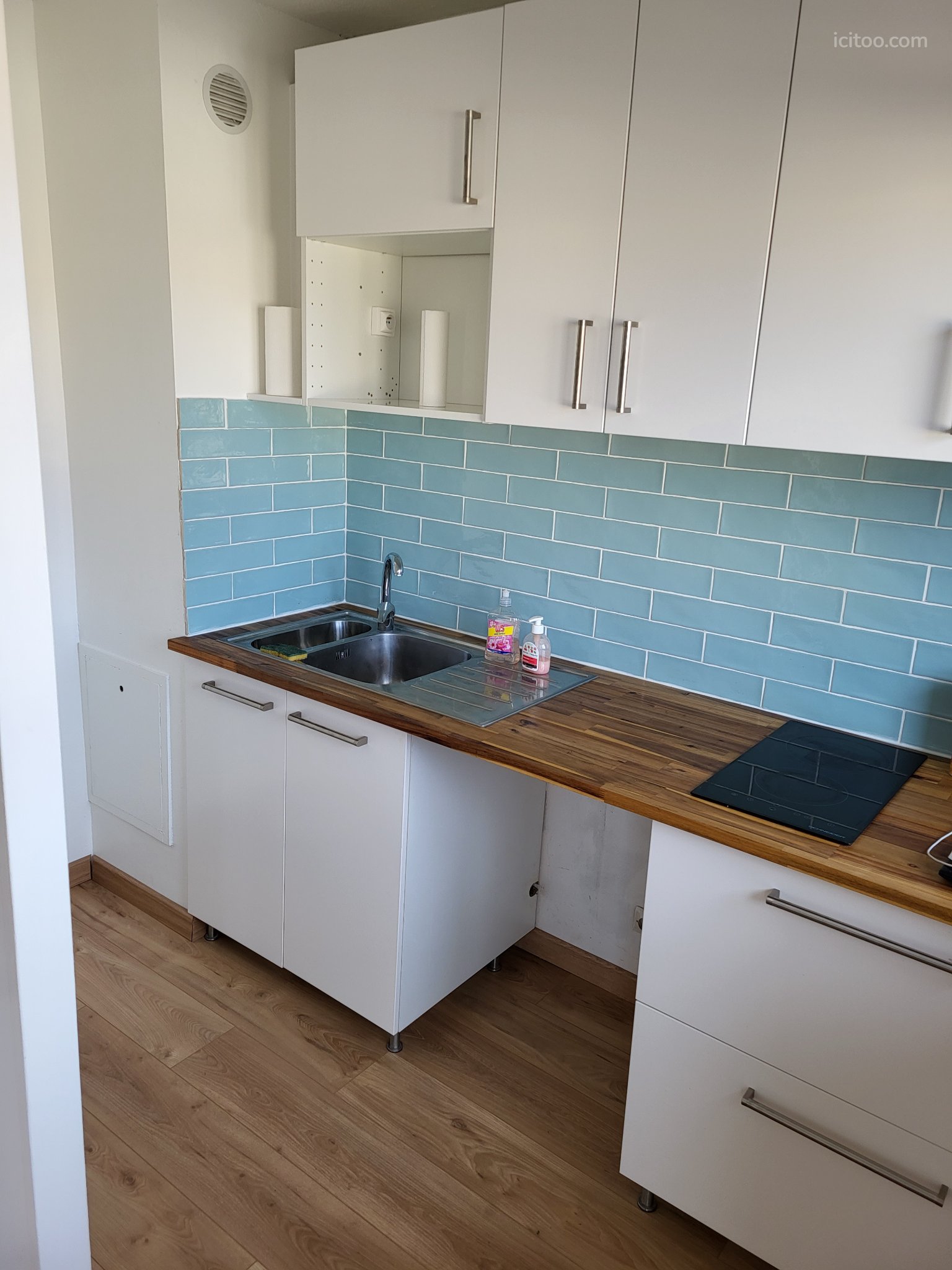 Appartement à louer à Mérignac : cuisine avec plan de travail bois et crédence bleue
