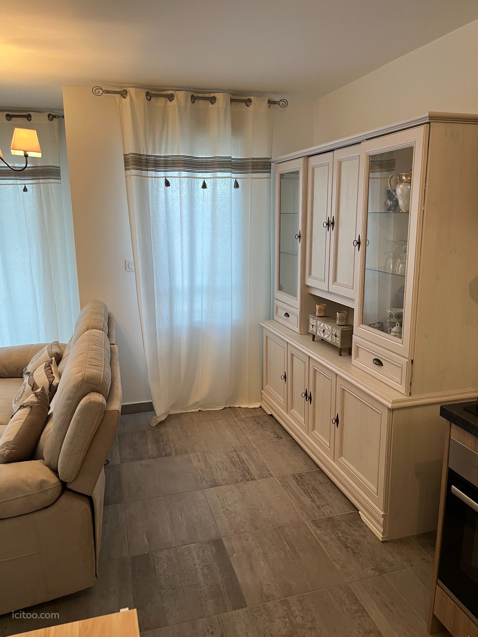 Appartement à vendre à Les Sables-d'Olonne : buffet haut en bois clair avec portes vitrées et tiroirs