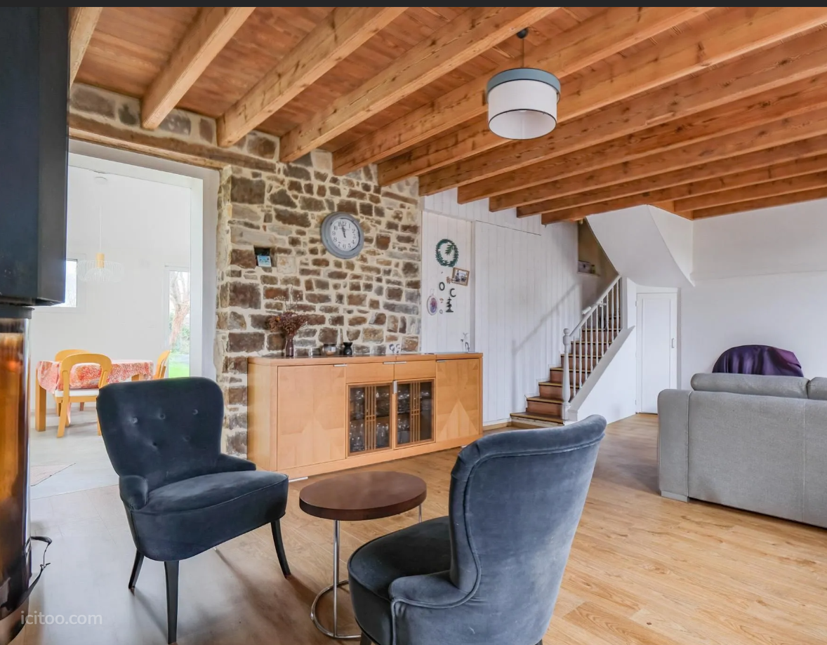 Maison à vendre à Fierville-les-Mines : séjour avec mur en pierre apparente et escalier
