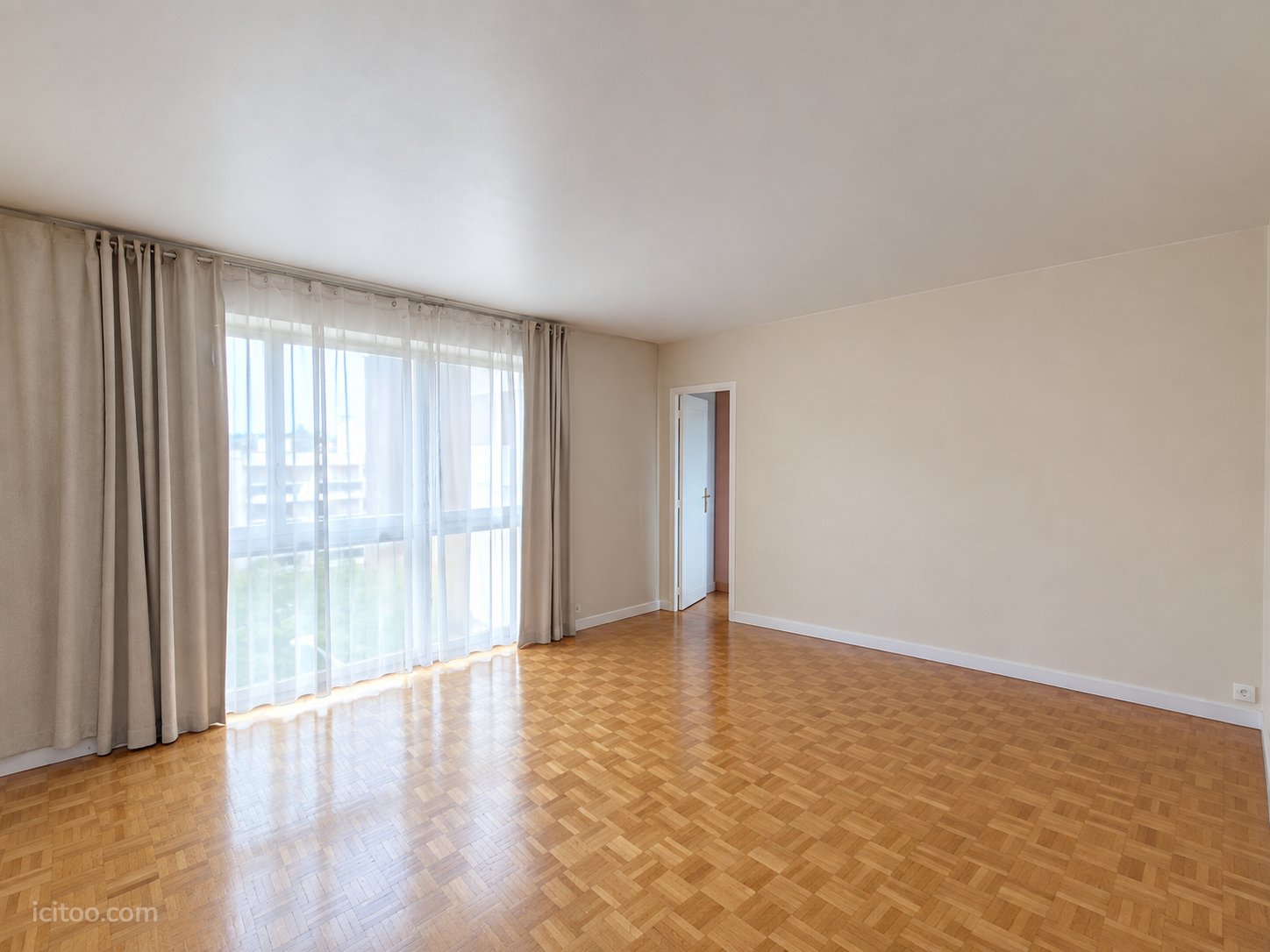 Appartement à vendre à Chatou : pièce de vie spacieuse avec parquet au sol et grandes fenêtres habillées de rideaux