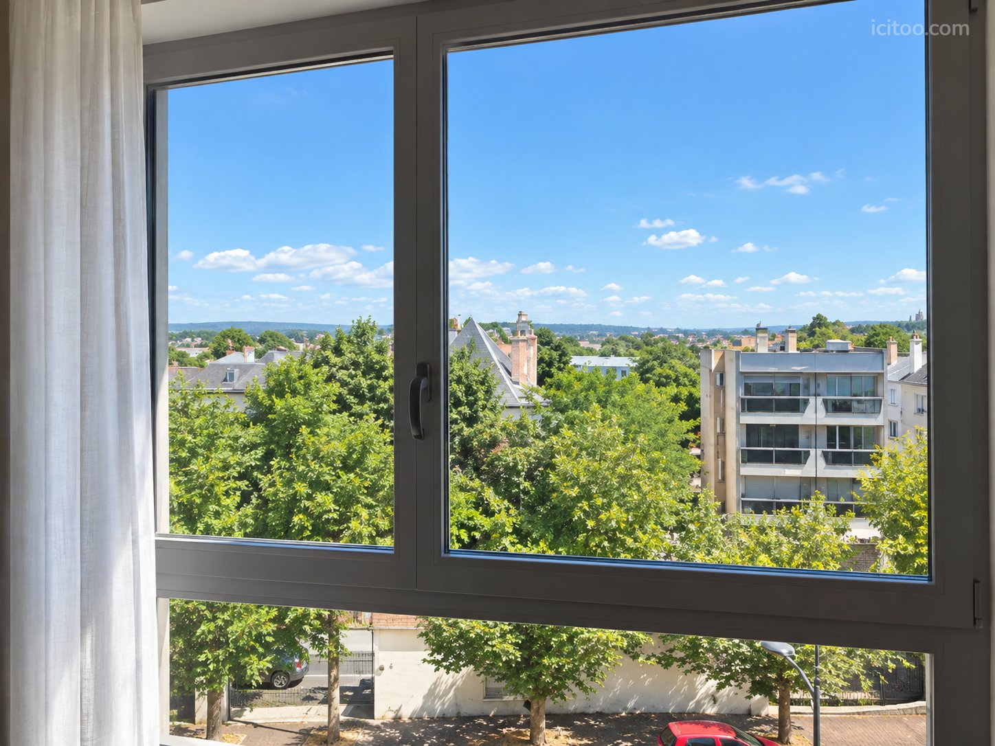 Appartement à vendre à Chatou : vue sur des maisons, des arbres et un ciel bleu avec quelques nuages
