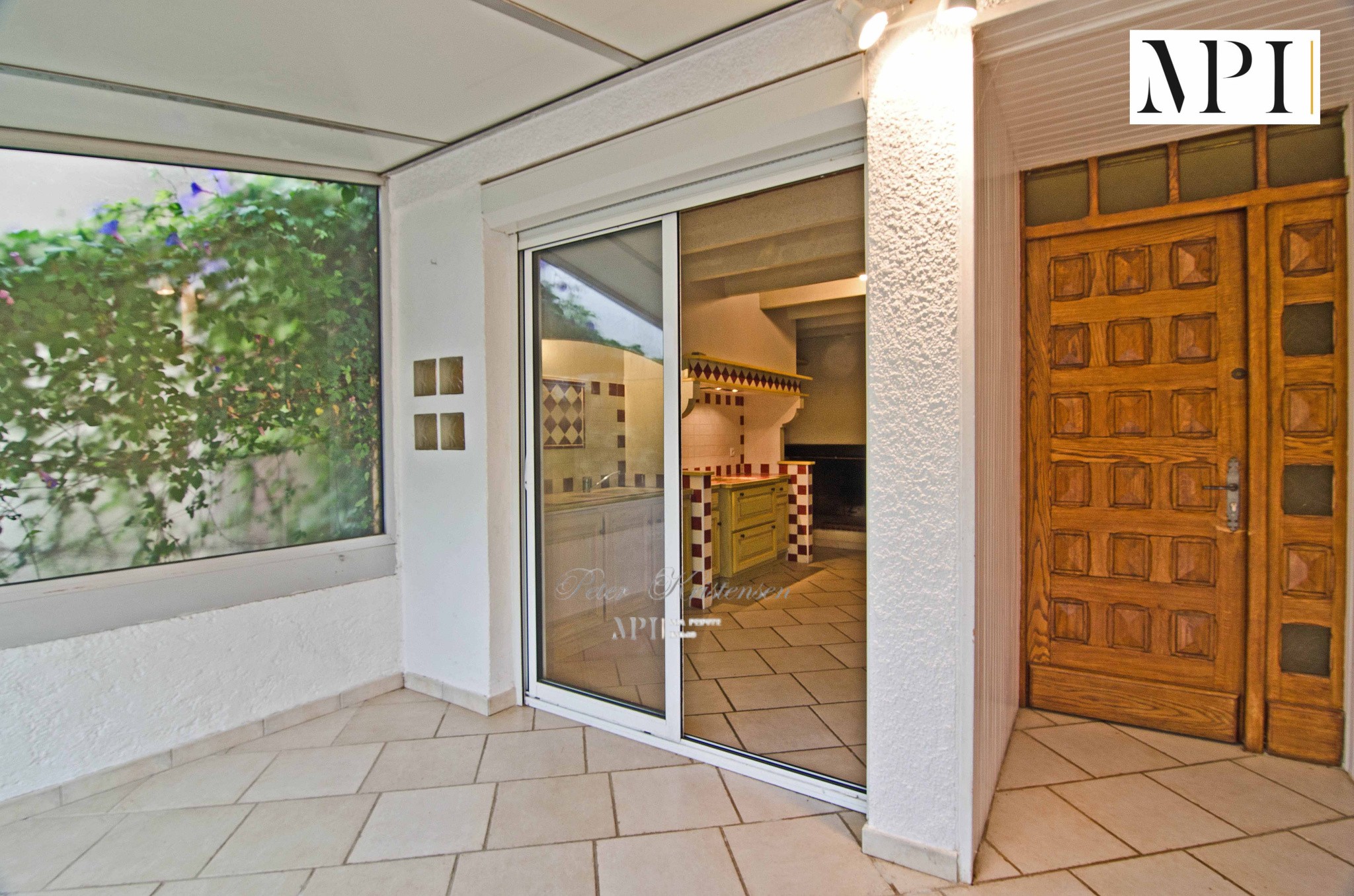 Maison à vendre à Trausse : entrée avec porte en bois et grande baie vitrée
