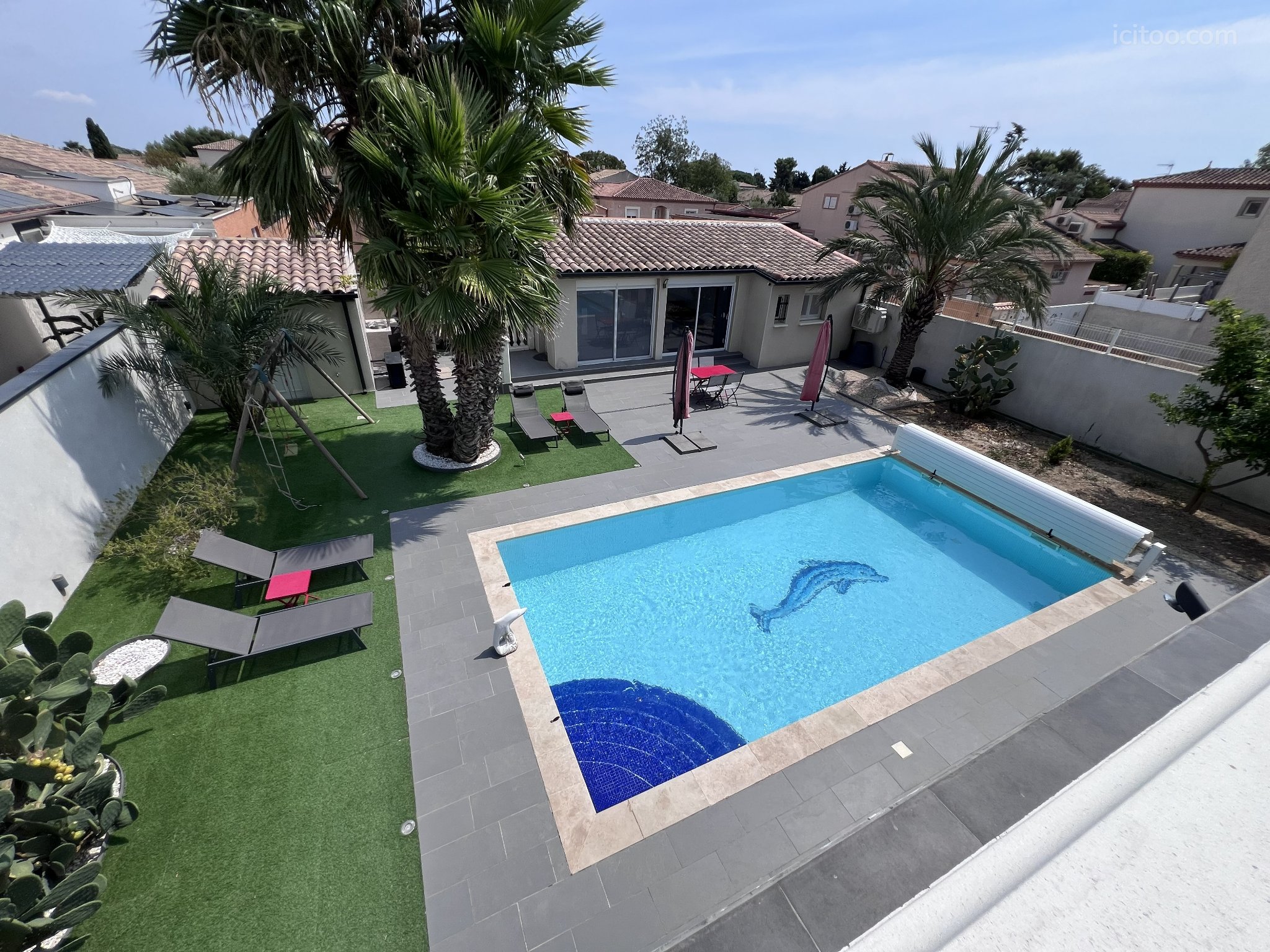 Villa 8 pièces à vendre à Montady (34310) : piscine rectangulaire avec motif dauphin et jardin avec palmiers