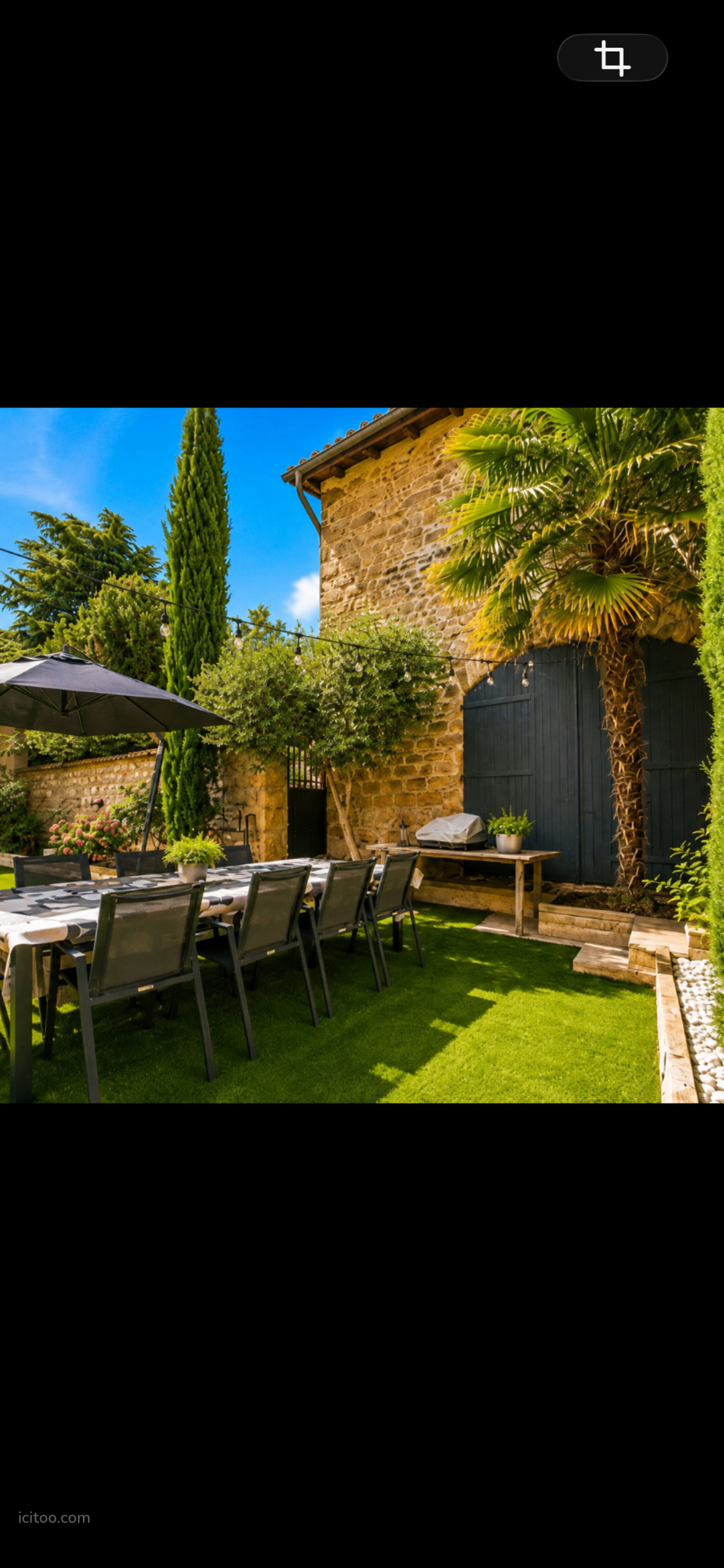 Villa à vendre à Millery : table dressée pour repas en extérieur, pelouse verte, palmier et mur en pierre