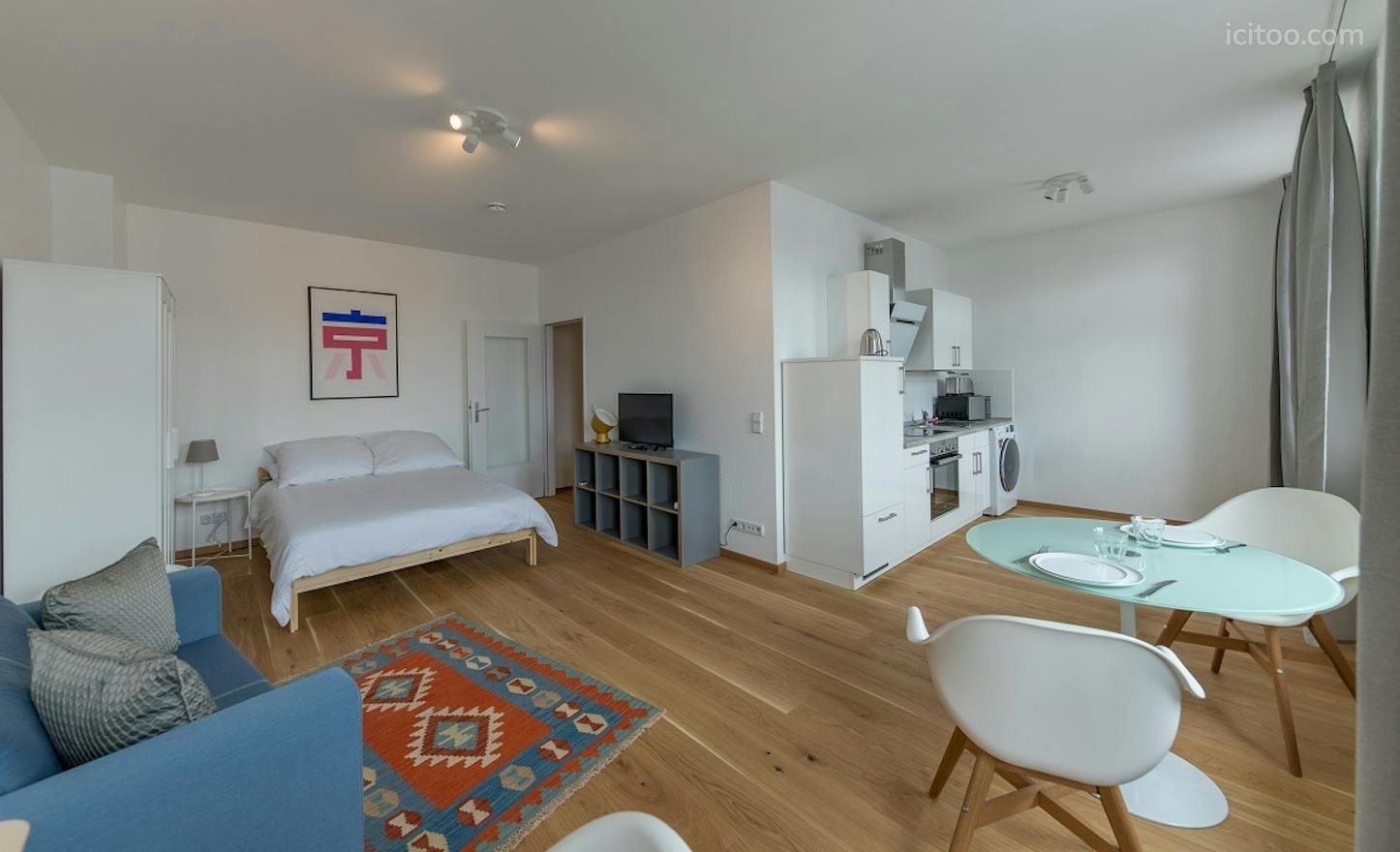 Studio à louer à Le Blanc-Mesnil (93150) : studio ouvert avec lit, canapé bleu et cuisine blanche