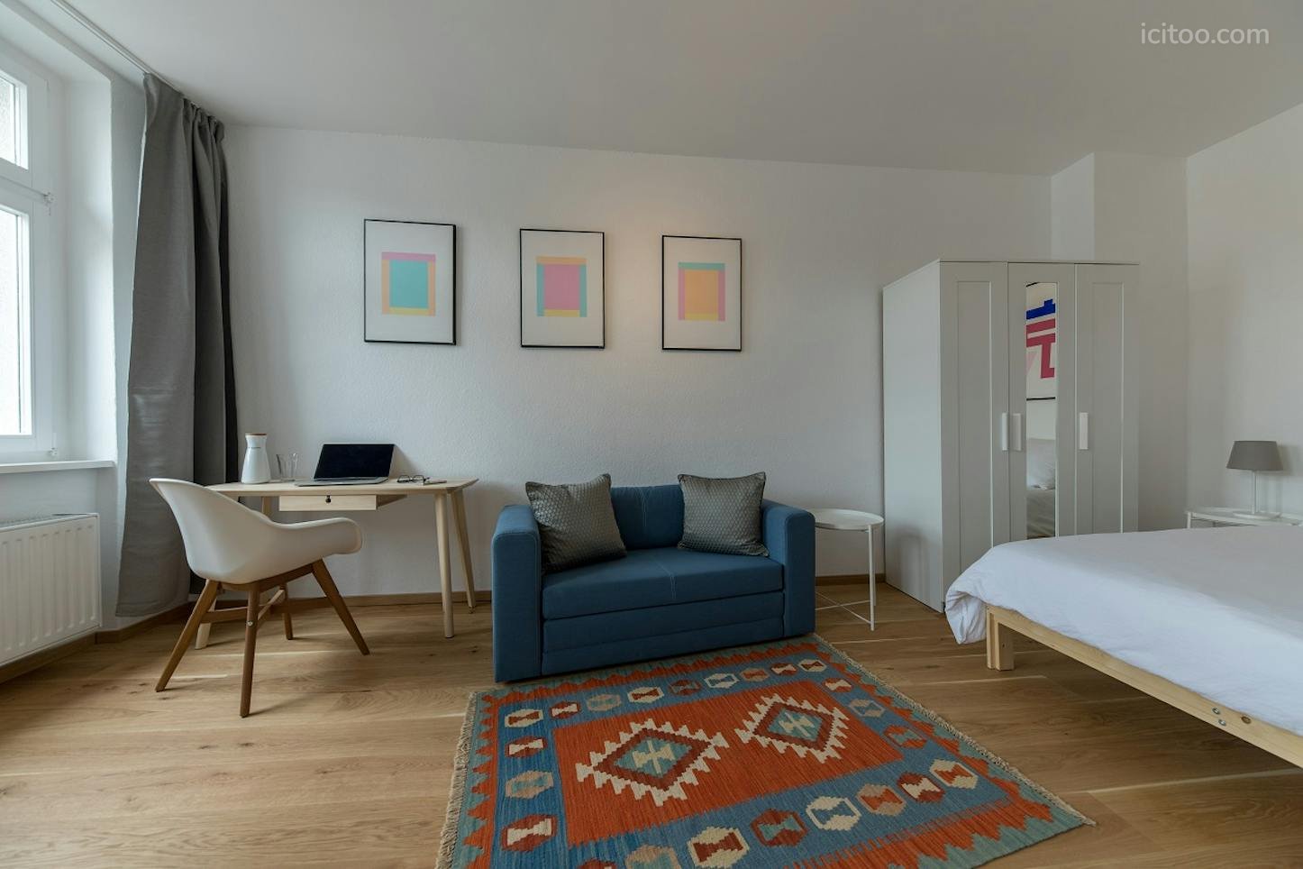 Studio à louer à Le Blanc-Mesnil : coin bureau avec chaise blanche et canapé bleu