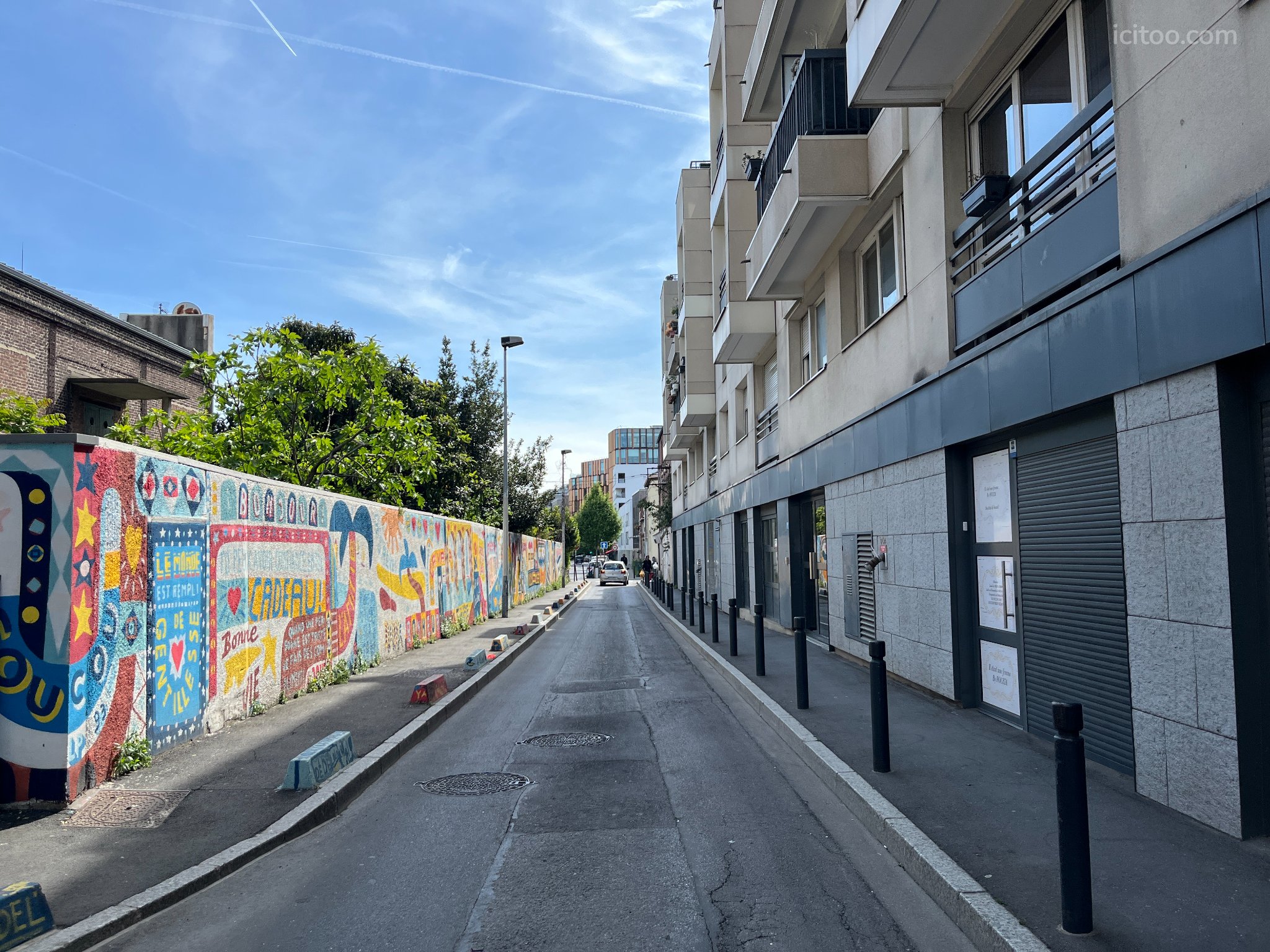 Local commercial à vendre à Saint-Denis (93210) : rue avec immeubles modernes et mur décoré de fresques colorées