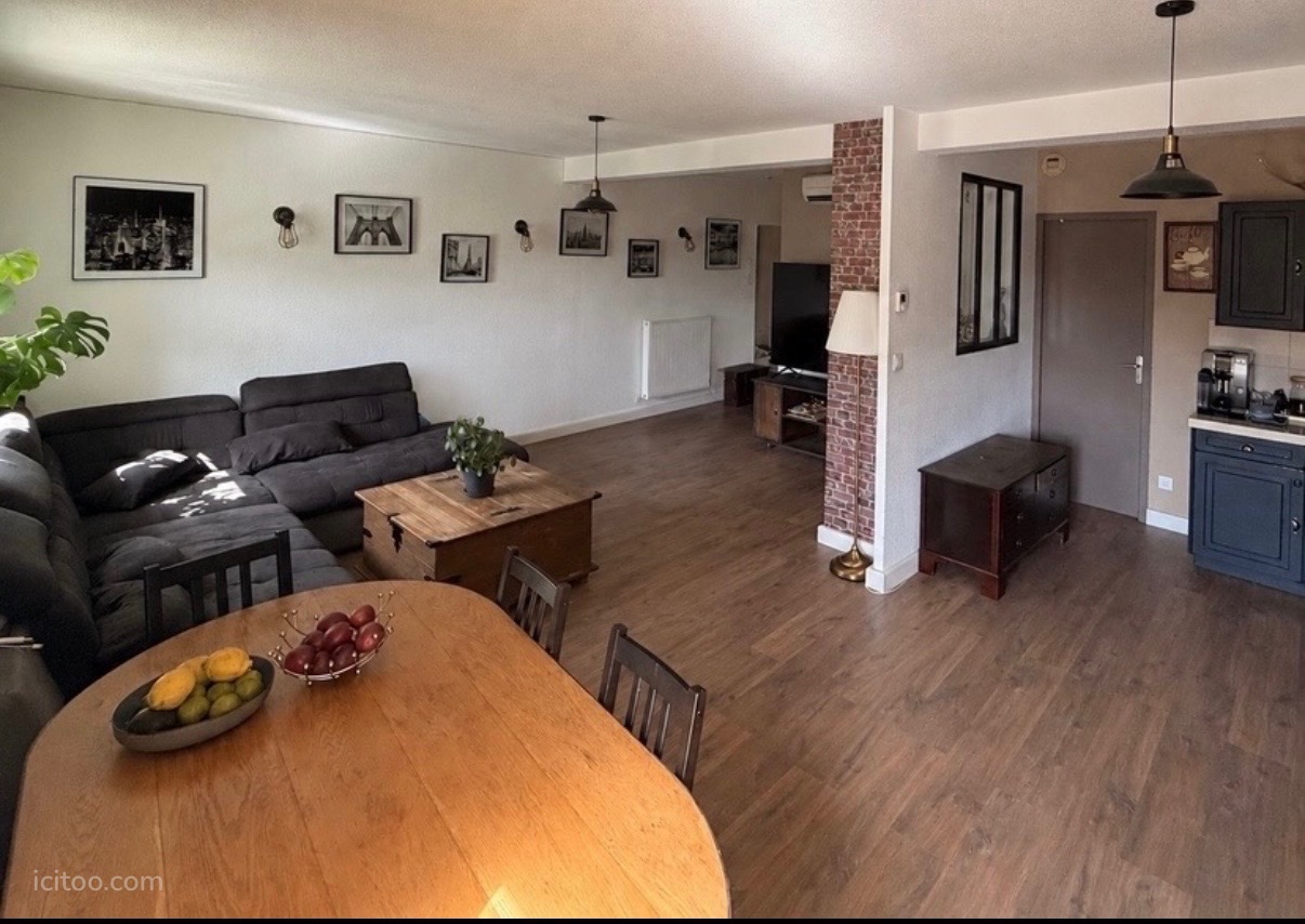 Appartement à vendre à Feyzin : canapé gris, table en bois et cadres au mur