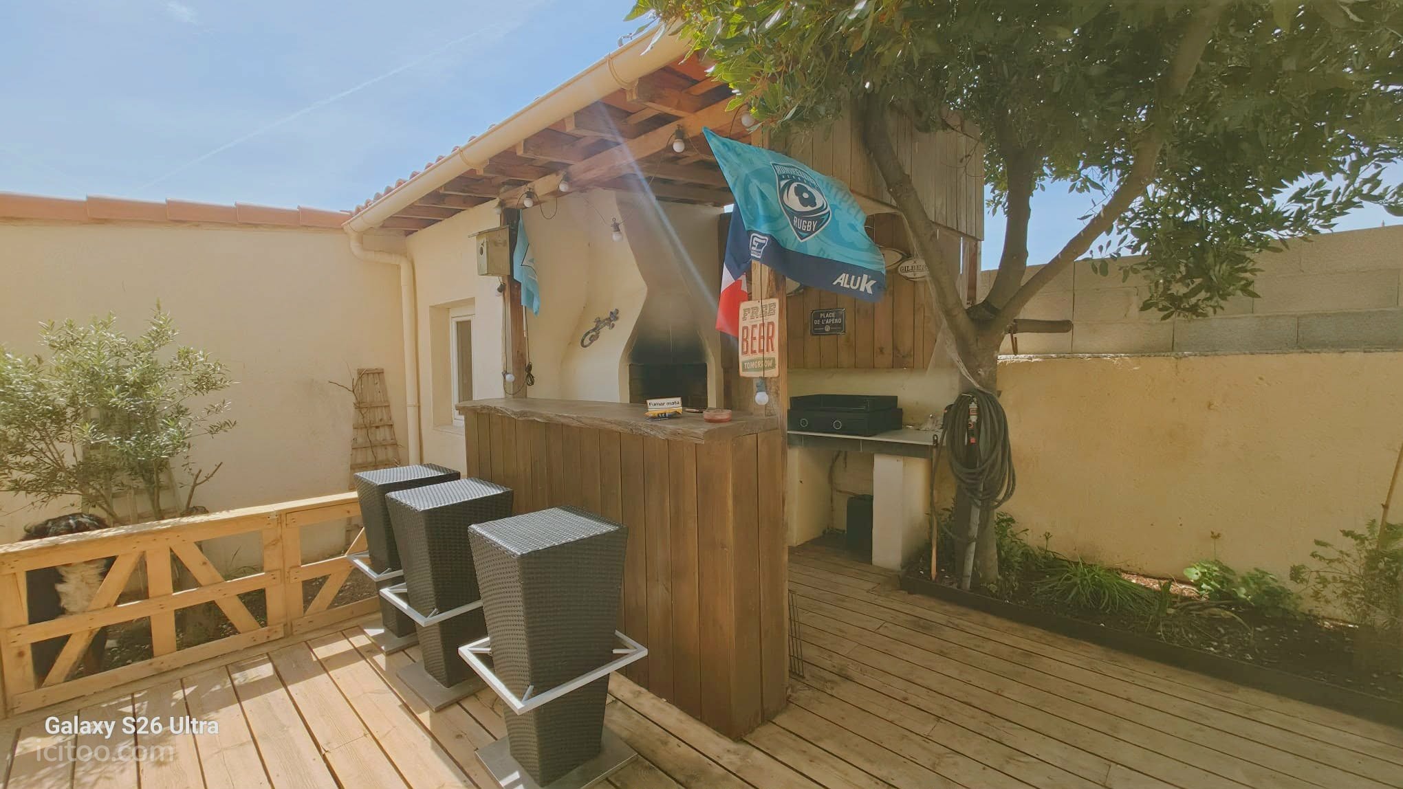 Maison à vendre à Frontignan : bar en bois avec tabourets noirs sous un abri