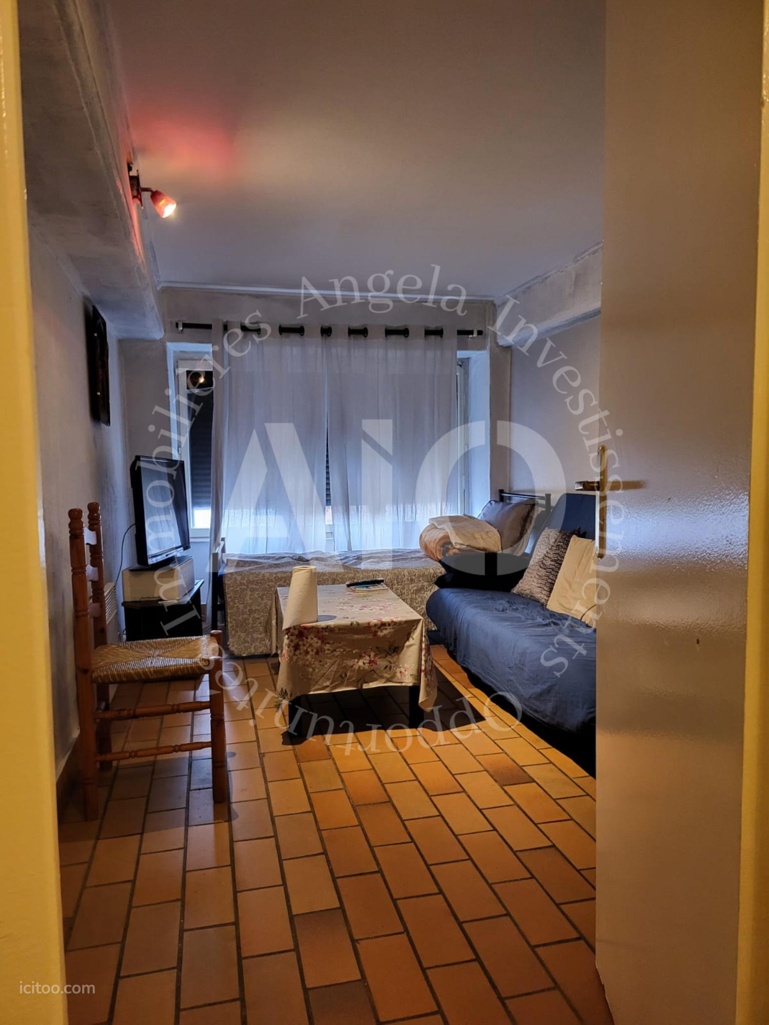 Appartement à vendre à Caluire-et-Cuire : chambre avec deux lits et sol en terre cuite