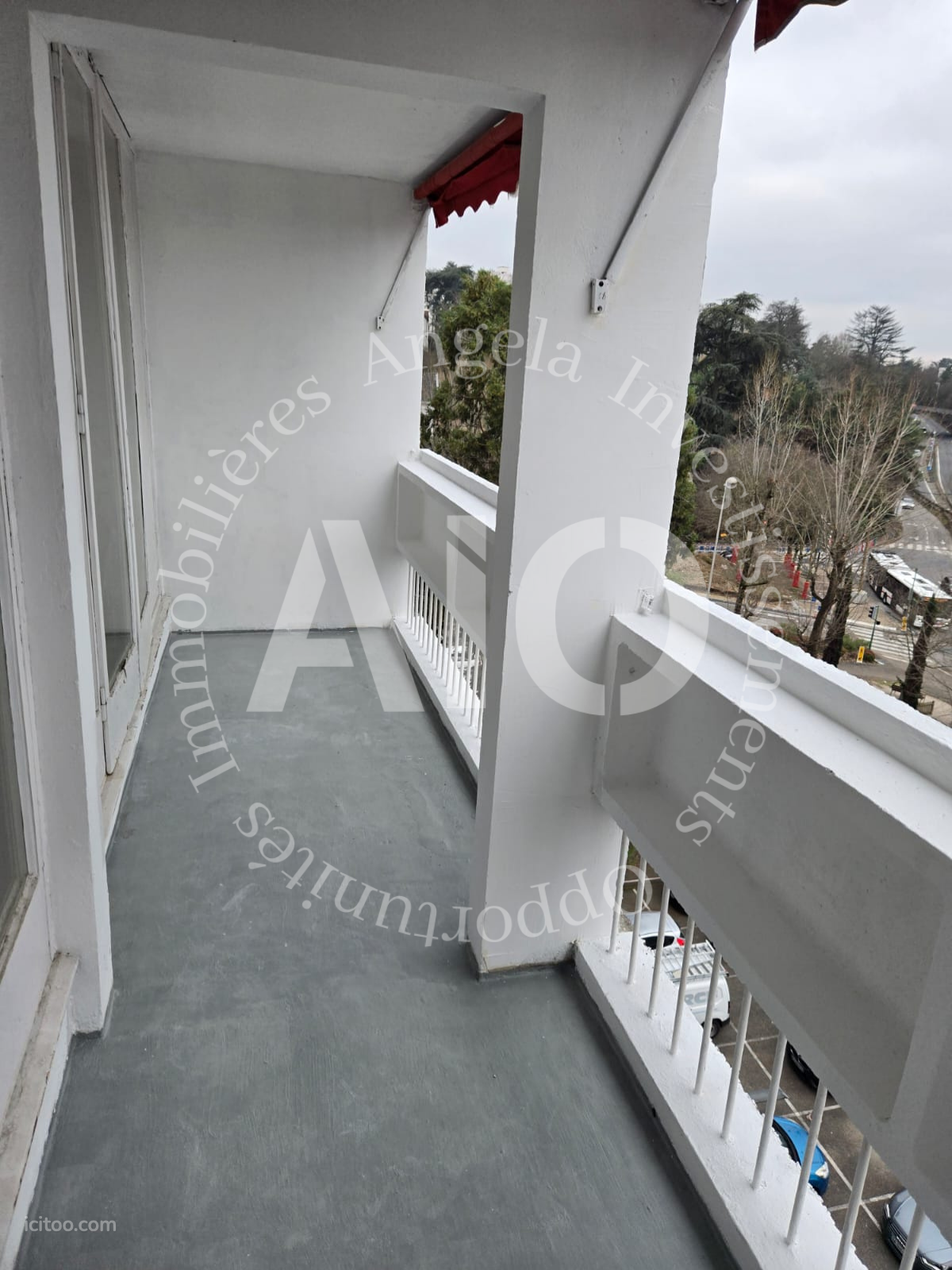 Appartement à vendre à Tassin-la-Demi-Lune : balcon étroit avec garde-corps blanc et sol gris