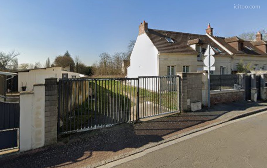 Terrain à vendre à Neuilly-en-Thelle : vue d'un portail métallique donnant sur un terrain avec pelouse