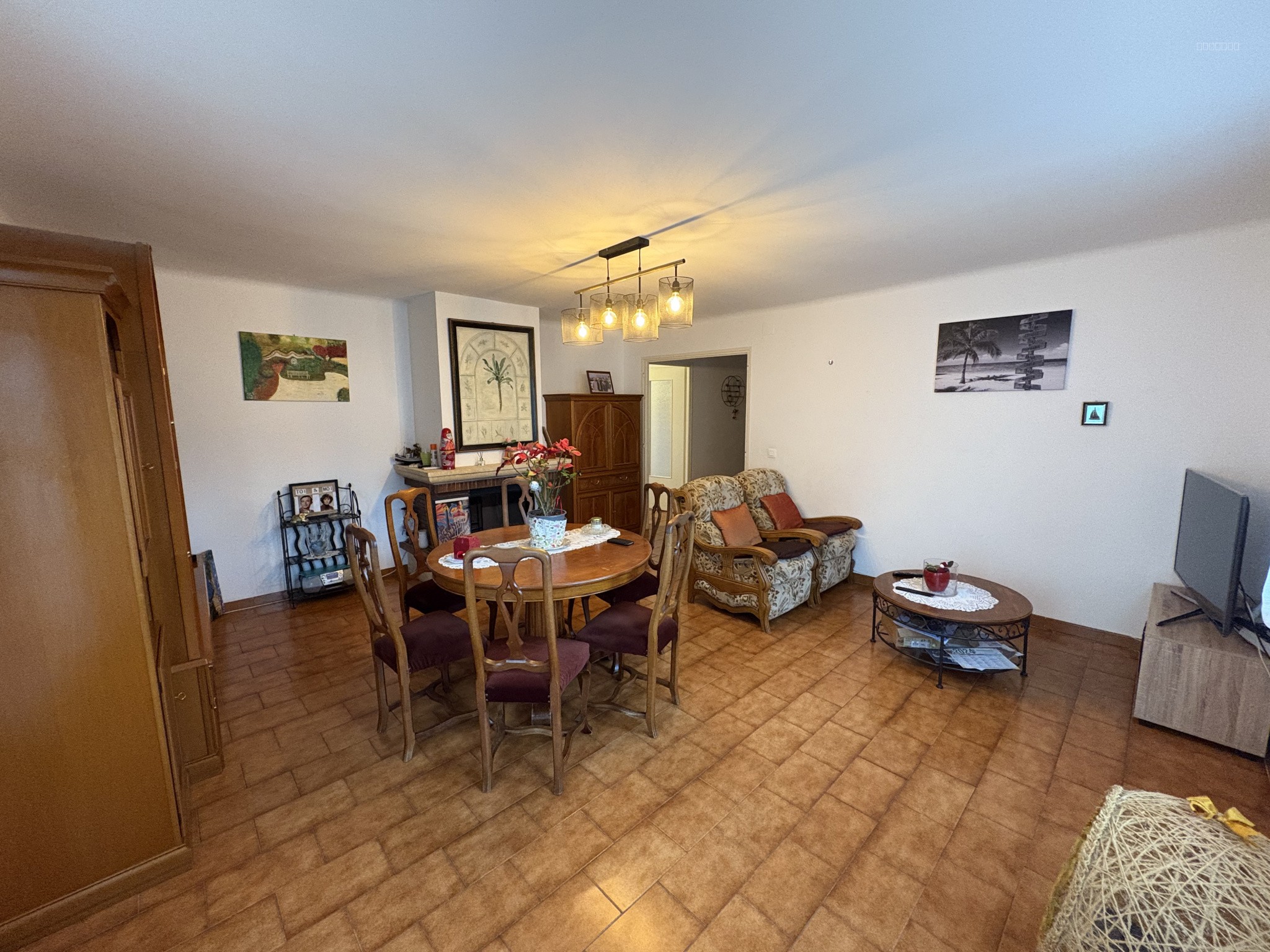 Appartement à vendre à Port vendres : salon avec table ronde, chaises et fauteuils à motifs
