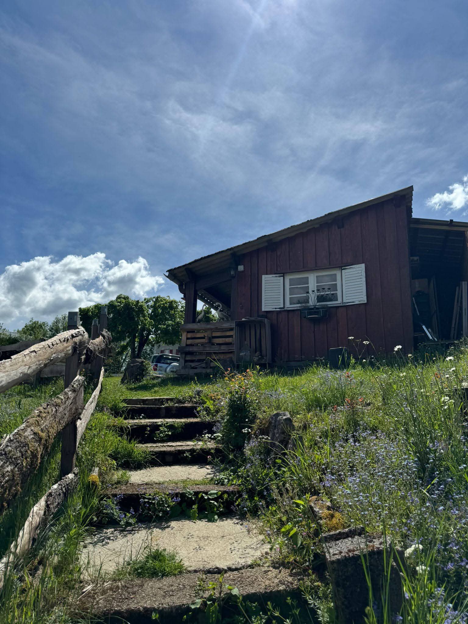 Maison à vendre à Bort-les-Orgues : dépendance en bois avec fenêtre à volets blancs